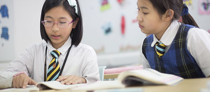Pupils in class studying text books