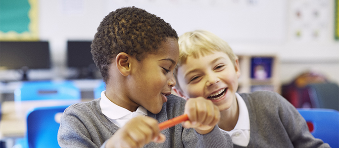 Two primary students enjoying studying together